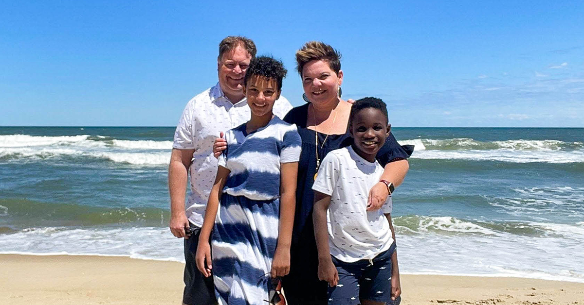 Susan, Capital One associate and mother, stand on the beach with her family
